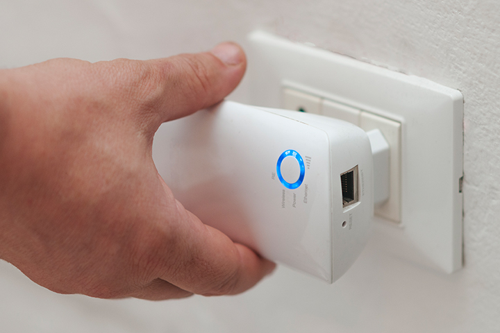 Hand Plugging in WiFi Extender