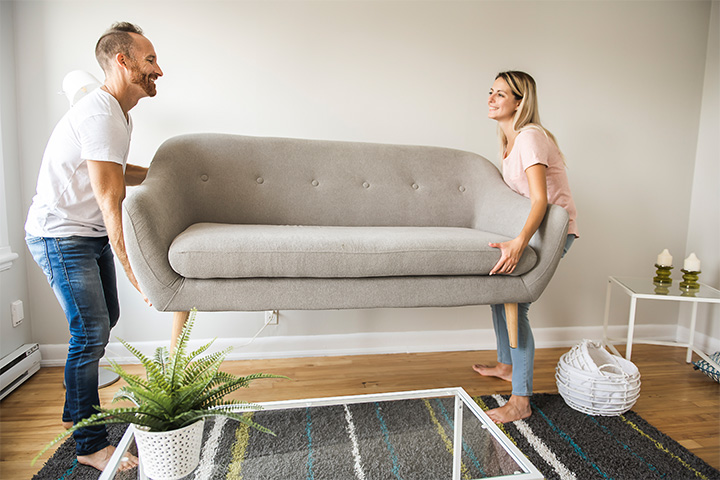 couple-moving-couch-in-living-room