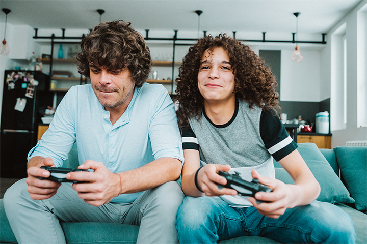 Two brothers playing video games on the couch