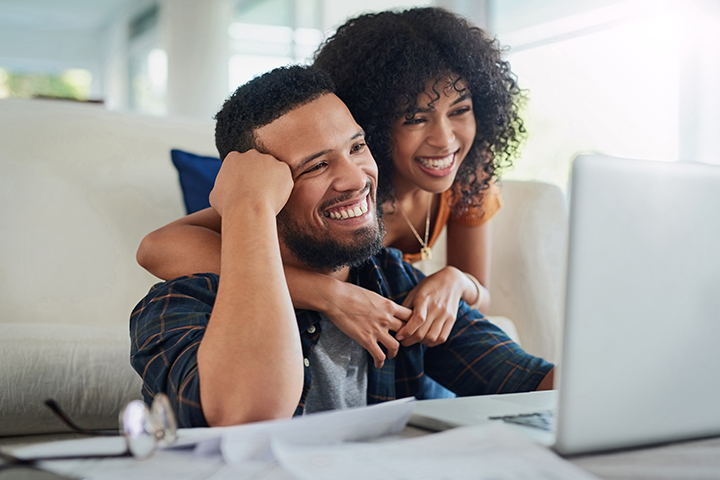 Couple smiling at laptop and internet perks